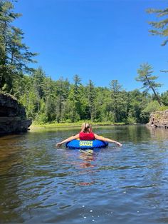 a woman is floating on a blue raft in the water