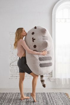 a woman is hugging a large stuffed animal