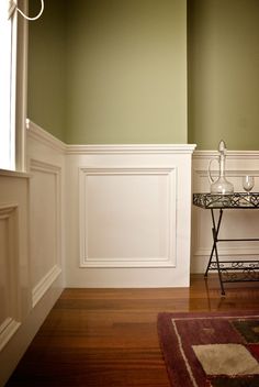 a table with two glasses on it sitting in front of a wall and door way