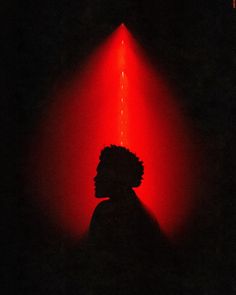 a person standing in the dark with a red light shining on their face and head