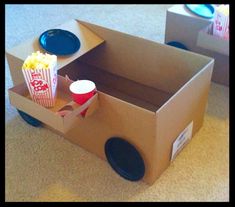 a cardboard box that has some popcorn in it and two plates on the floor next to it