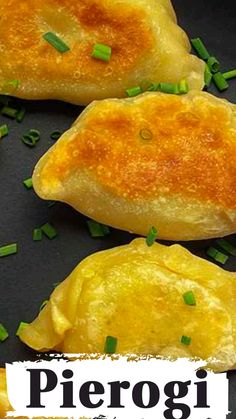 three pieces of food on a black plate with green onions and the words pierogi