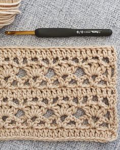 the crochet pattern is next to a ball of yarn and a knitting needle