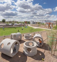 children play in an outdoor playground with concrete structures