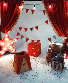 red and white christmas decorations on display in front of a curtained room with presents