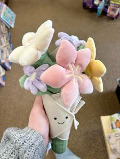 a person holding a bouquet of flowers in their hand at the grocery store or department