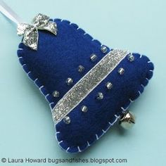 a blue christmas tree ornament with silver sequins and bows on it