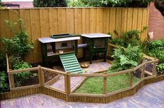 a small backyard with a wooden fence and green lawn furniture in the middle of it