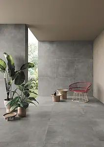 a room with some plants in pots on the floor and a chair next to it