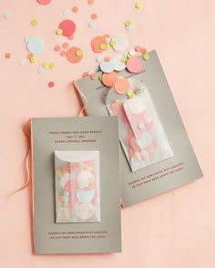 two packages with confetti on them sitting next to each other