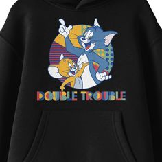 Celebrate your favorite cartoon characters with this Tom & Jerry sweatshirt. The hoodie features an image of Tom and Jerry in a colorful circle while multicolored letters below the characters read, "Double Trouble." The sweatshirt comes in black with a double-lined hood and a large pouch pocket. Fans of the Tom & Jerry cartoons will love this comfy sweatshirt. Black Cartoon Print Hoodie Top, Black Hooded Top With Cartoon Print, Fun Cotton Hoodie With Cartoon Print, Casual Cartoon Print Hoodie For Fans, Pop Culture Long Sleeve Hoodie With Letter Print, Playful Cartoon Print Hoodie, Playful Hoodie With Cartoon Print, Cartoon Style Cotton Top With Letter Print, Cotton Cartoon Style Tops With Letter Print