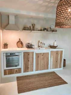 a kitchen with white walls and wooden cabinetry on the counter top, along with a rug