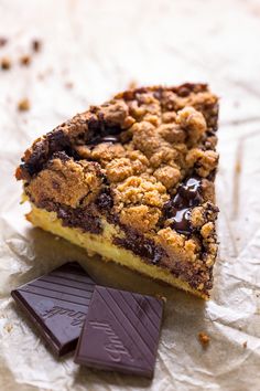 a piece of chocolate chip pie next to a bar of milkshake on wax paper