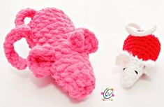 two crocheted toys are sitting next to each other on a white surface, one is pink and the other is red