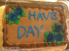 a cake with frosting that says have day on it and blue roses in the middle