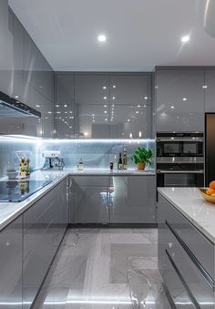 a modern kitchen with stainless steel cabinets and marble counter tops, along with an island in the middle