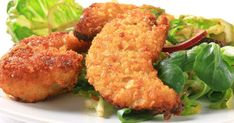 some fried food on a white plate with lettuce