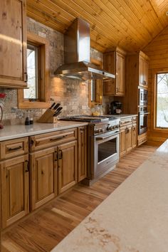 a large kitchen with wooden cabinets and stainless steel stove top oven in the center of the room