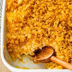 a casserole dish with wooden spoon in it