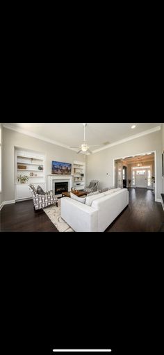 a living room filled with furniture and a flat screen tv mounted on a wall above a fireplace