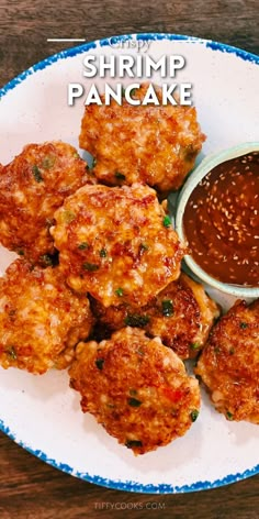 some food is sitting on a plate with dipping sauce in the middle and words shrimp pancake above it