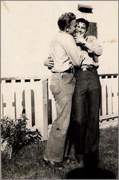 an old black and white photo of two people hugging