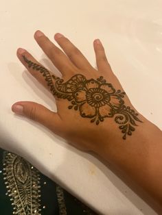 a person's hand with a henna tattoo on it