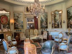 an ornately decorated living room with paintings on the walls and furniture in it,