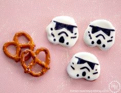 star wars themed cookies and pretzels on a pink surface