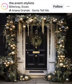 the front door is decorated with gold ornaments and greenery