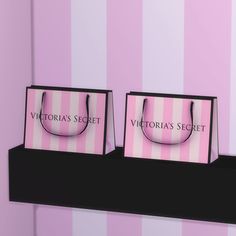 two paper bags sitting on top of a shelf in front of a pink striped wall