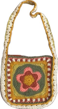 a crocheted purse with a flower on the front and side, hanging from a rope