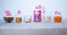 a table topped with glasses filled with different types of drinks and cereals next to each other