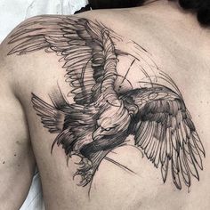 a man's back with a bird tattoo on it