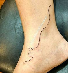 a woman's foot with a cat tattoo on it