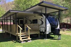 a white and black rv parked under a metal awning