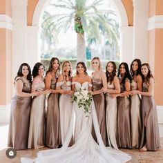 a group of women standing next to each other in front of a building with palm trees