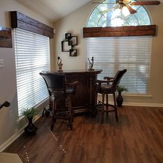 a dining room table and chairs in front of a window with blinds on the windowsill