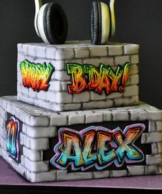 a cake made to look like headphones and bricks with the word alex on top