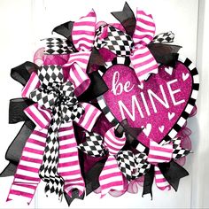 a pink and black heart wreath with the words be mine