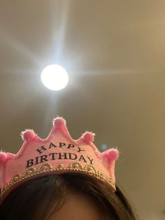 a woman wearing a pink birthday crown with the words happy birthday written on it's side