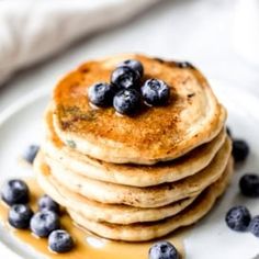 a stack of pancakes with blueberries and syrup