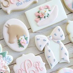 decorated cookies are arranged on a table with pink and blue decorations, such as flowers