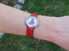 a woman's wrist with a watch on it that has an image of a clown