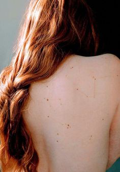 the back of a woman's head with freckles on her skin and hair