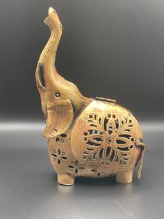 an elephant figurine sitting on top of a table next to a gray wall