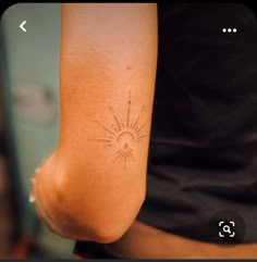 a woman's arm with a tattoo on it and the sun in the middle