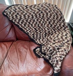 a couch with a blanket on top of it next to a radiator heater