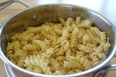 a pot filled with pasta on top of a wooden table