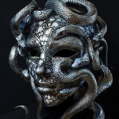 a person wearing a mask with snakes on it